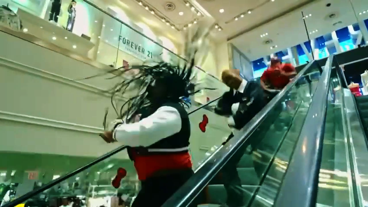 A dancer whips her braids mid-move on an escalator