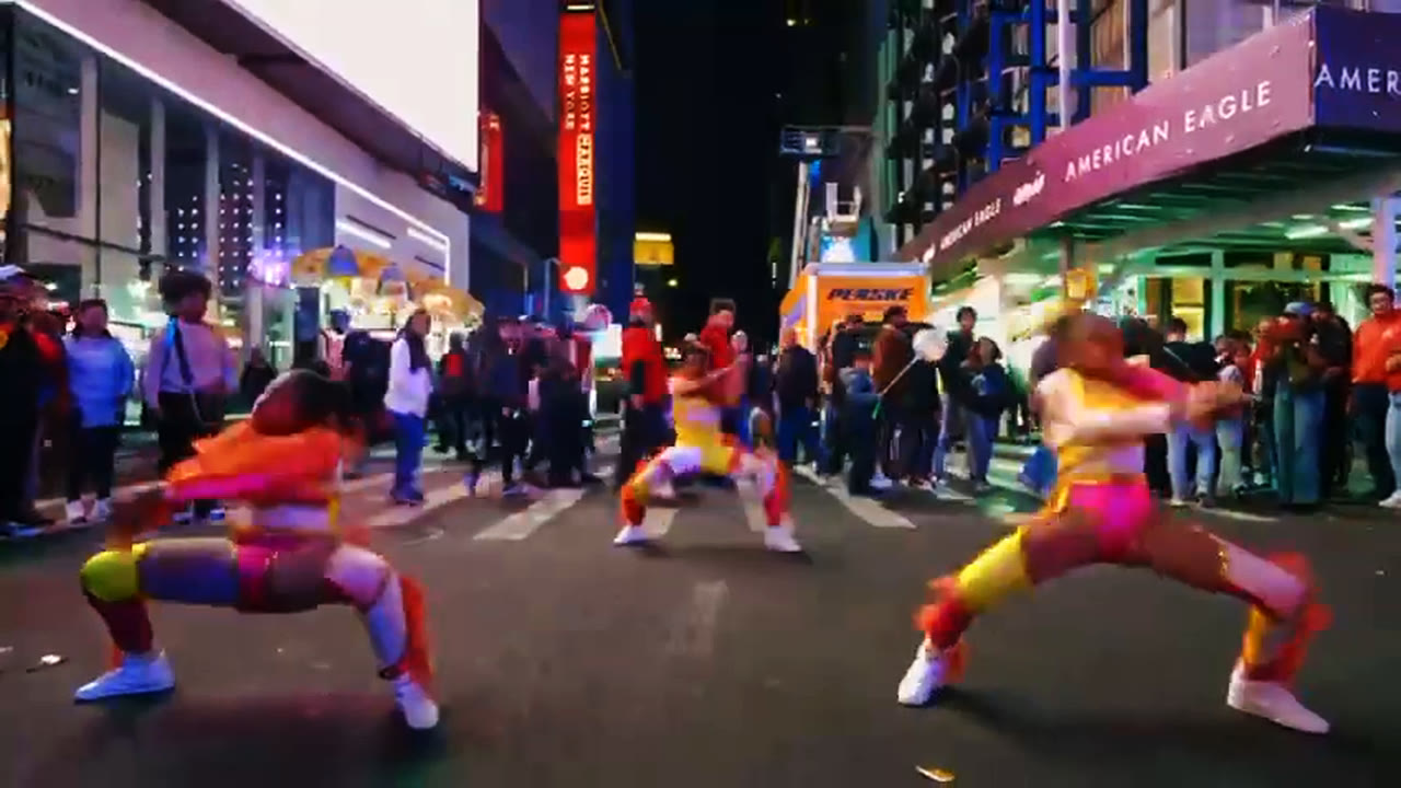 Performers drop into deep lunges in front of a watching crowd