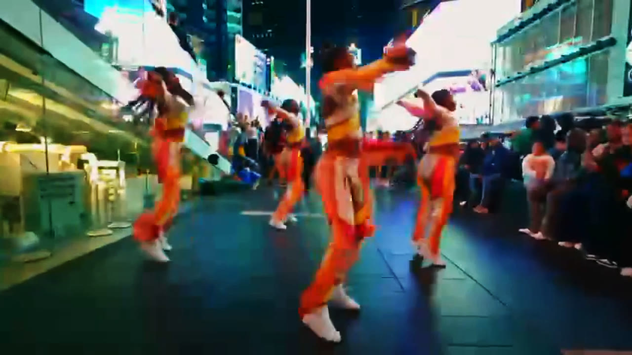 A costumed team charges forward down a lit pedestrian plaza